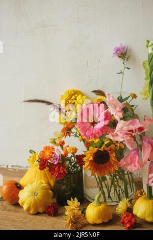 Élégante composition automnale sur fond rustique. Fleurs d'automne colorées, citrouilles, patypan squashes encore la vie. Carte de vœux Seasons. Récolte Banque D'Images