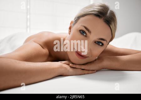 Belle femme se détend sur la table de massage après se détendre dans le spa et le massage. Massage corporel pour femme Banque D'Images