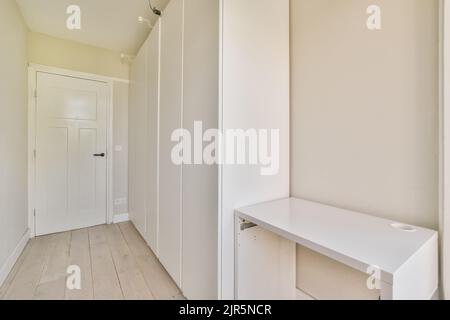 Intérieur moderne plat de style minimaliste avec couloir vide étroit éclairé par des lampes Banque D'Images