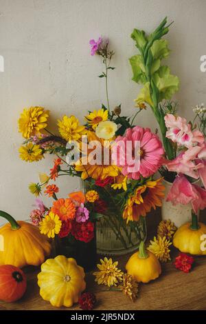 Joyeux Thanksgiving ! Automne moody encore la vie, image atmosphérique. Fleurs d'automne colorées, citrouilles, patypan de la composition contre le mur rustique. Banque D'Images