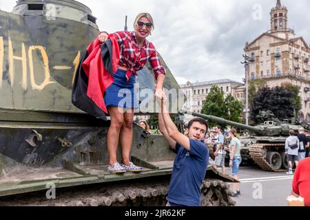 Kiev, Ukraine. 20th août 2022. Une femme avec un drapeau rouge et noir de l'organisation des nationalistes ukrainiens pose sur une arme automotrice détruite. Une exposition de matériel russe détruit est organisée sur Khreshchatyk. Il y a six mois, le président russe Vladimir Poutine avait ordonné à ce matériel militaire d'envahir l'Ukraine. Il aurait estimé qu’ils s’emparaseraient de Kiev en trois jours. Crédit : SOPA Images Limited/Alamy Live News Banque D'Images