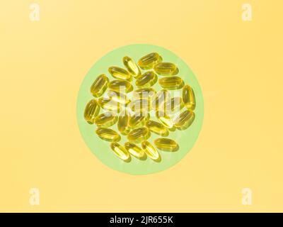 Capsules liquides de vitamine D3 ou d'Omega ou d'huile de Primrose du soir sur un cercle vert sur fond jaune. Vue de dessus ou plat concept minimaliste avec capsules d'huile jaune liquide Banque D'Images