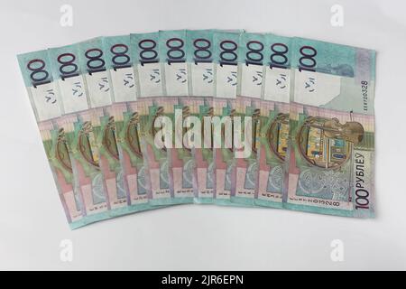 Billets en valeurs unitaires de 100 roubles biélorusses disposés sur fond gris Banque D'Images