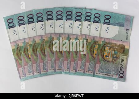 Billets en valeurs unitaires de 100 roubles biélorusses disposés sur fond gris Banque D'Images