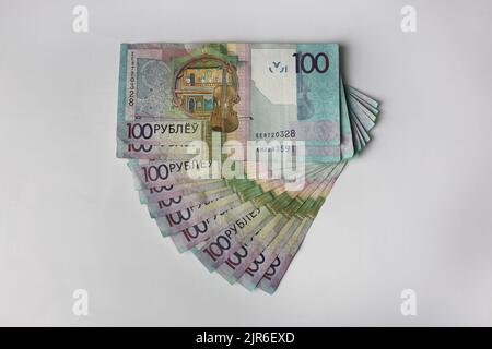 Billets en valeurs unitaires de 100 roubles biélorusses disposés sur fond gris Banque D'Images