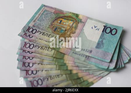 Billets en valeurs unitaires de 100 roubles biélorusses disposés sur fond gris Banque D'Images