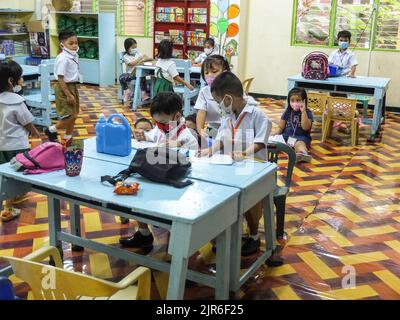 Malabo City, Philippines. 22nd août 2022. Les jeunes élèves écrivent leur nom sur un papier lors de leur première journée d'école. Après deux années d'école sans cours en face à face, les couloirs et les salles de classe vides seront remplis une fois de plus d'élèves, puisque le ministère de l'éducation (Depud) ouvre officiellement le début de l'année scolaire 2022-2023 le lundi 22 août. Crédit : SOPA Images Limited/Alamy Live News Banque D'Images