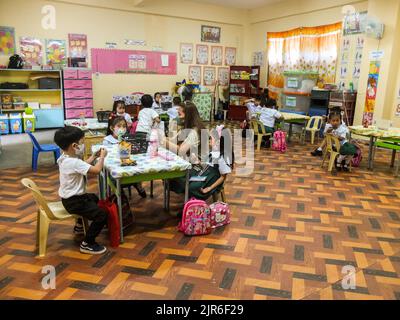 Malabo City, Philippines. 22nd août 2022. Une enseignante a vu aider ses jeunes élèves pendant le congé ou le repas du milieu de la matinée. Après deux années d'école sans cours en face à face, les couloirs et les salles de classe vides seront remplis une fois de plus d'élèves, puisque le ministère de l'éducation (Depud) ouvre officiellement le début de l'année scolaire 2022-2023 le lundi 22 août. Crédit : SOPA Images Limited/Alamy Live News Banque D'Images