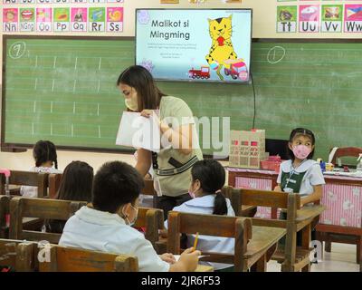 Malabo City, Philippines. 22nd août 2022. Une enseignante a vu aider son élève par écrit. Après deux années d'école sans cours en face à face, les couloirs et les salles de classe vides seront remplis une fois de plus d'élèves, puisque le ministère de l'éducation (Depud) ouvre officiellement le début de l'année scolaire 2022-2023 le lundi 22 août. Crédit : SOPA Images Limited/Alamy Live News Banque D'Images