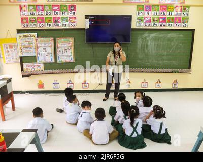 Malabo City, Philippines. 22nd août 2022. Une enseignante a vu donner une orientation à ses jeunes élèves. Après deux années d'école sans cours en face à face, les couloirs et les salles de classe vides seront remplis une fois de plus d'élèves, puisque le ministère de l'éducation (Depud) ouvre officiellement le début de l'année scolaire 2022-2023 le lundi 22 août. Crédit : SOPA Images Limited/Alamy Live News Banque D'Images