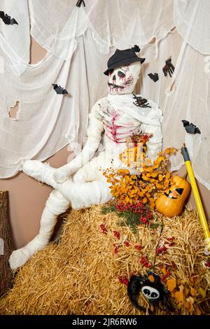Squelette fait à partir de bandages pour la décoration d'Halloween est assis sur une balle de foin Banque D'Images