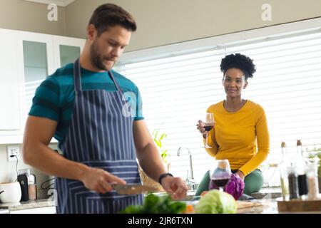 Image d'un couple varié préparant un repas ensemble dans la cuisine Banque D'Images
