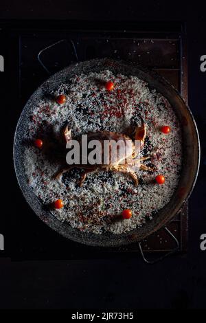 Crabe frais avec tomates cerises et riz dans la casserole Banque D'Images