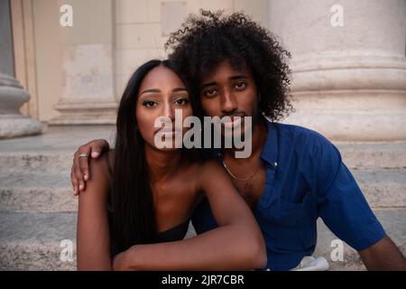 Deux beaux jeunes amis assis sur les marches du centre-ville prennent de l'air. Banque D'Images