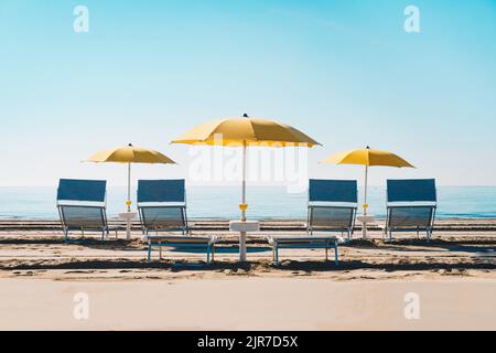 Plage idyllique avec parasol et transats à la mer Adriatique. Scène typique au bord de la mer en Italie, en Europe pendant l'été. Banque D'Images