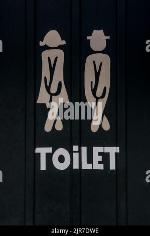 Panneau blanc de toilet sur une porte noire montrant des silhouettes d'un homme et d'une femme, Danemark, 8 août 2022 Banque D'Images