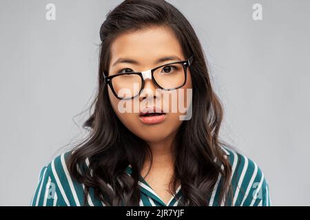 portrait d'une femme asiatique confuse en lunettes Banque D'Images