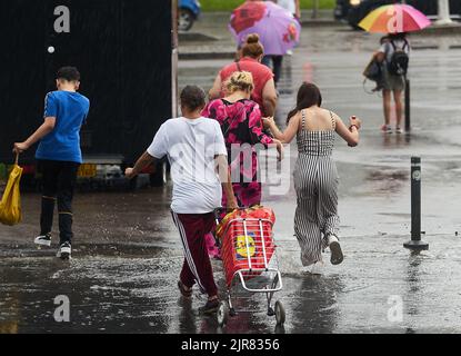 Bucarest, Roumanie - 17 juin 2022 : les gens traversent la rue sous une forte pluie. Banque D'Images