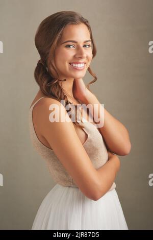 Le bonheur vous semble magnifique. Photo en studio d'une jeune femme attrayante posant sur un fond marron. Banque D'Images