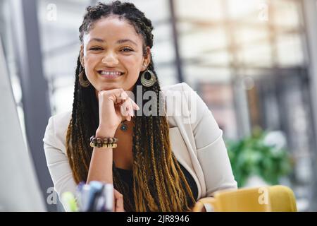 Le succès met toujours un sourire sur mon visage. Portrait court d'une jeune femme d'affaires attirante assise à son bureau. Banque D'Images