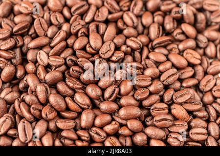Fond de grains de café torréfiés. Photo macro des grains de café frits sur la table. Banque D'Images