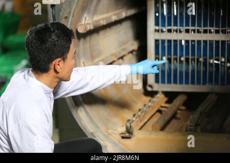 Travailleurs asiatiques travaillant dans l'industrie alimentaire et des boissons pour l'usine de l'industrie des boissons avec travail d'hygiène personnel d'inspecteur de ligne de production de jus de fruits. Inspecter le faisceau Banque D'Images