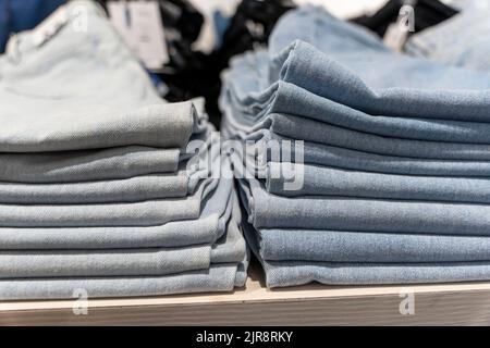 une pile de jeans bleus sur une étagère dans le magasin. magasin de vêtements de mode Banque D'Images