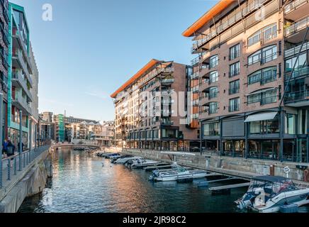 Oslo, Norvège - 13 août 2022 : vue en soirée sur le front de mer de Tjuvholmen, avec bateaux et bâtiments face au canal. Banque D'Images