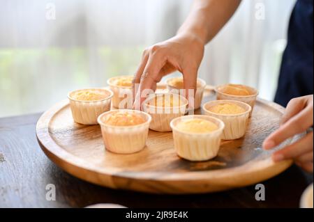 Coupe courte de femme qui fait cuire un cupcake dans la cuisine pendant son temps libre Banque D'Images