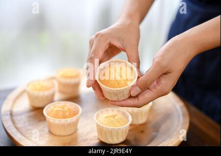 Vue rapprochée d'une femme montrant un cupcake frais à l'appareil photo, faisant du cupcake Banque D'Images