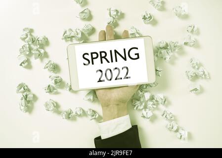 Affiche textuelle indiquant le printemps 2022. Concept d'affaires période de l'année où les fleurs s'élèvent après la saison d'hiver papier enroulent sous l'écran de téléphone avec Banque D'Images