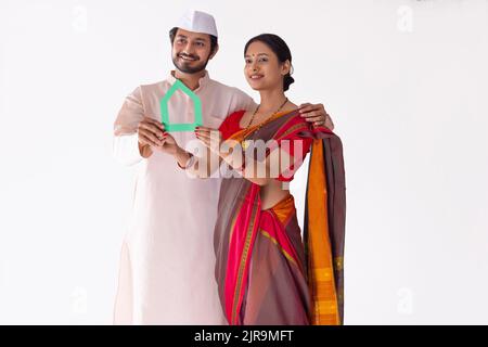 Portrait du couple Maharashtrian tenant leur nouveau rêve à la maison entre les mains Banque D'Images