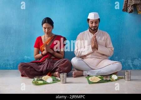 Un couple Maharashtrian priant avant le déjeuner Banque D'Images