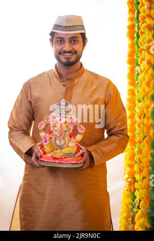 Portrait d'un homme Maharashtrian portant la statue de Lord Ganesh Banque D'Images