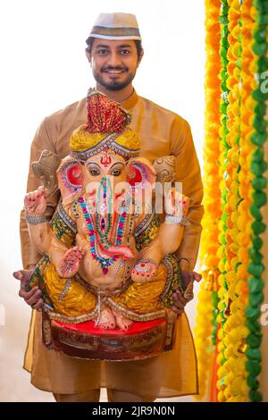 Portrait d'un homme Maharashtrian portant la statue de Lord Ganesh Banque D'Images