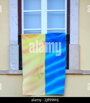 Le drapeau ukrainien est accroché à une fenêtre pour montrer sa solidarité Banque D'Images