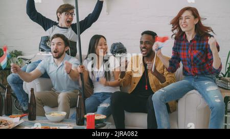 Divers groupes d'amis fans de sport avec drapeaux nationaux hollandais regardant des jeux de sports d'hiver à la télévision ensemble acclamé l'équipe préférée à la maison à l'intérieur Banque D'Images