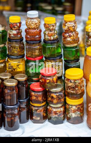 Il y a beaucoup de bocaux de miel biologique, naturel sur le comptoir à vendre. Différents miel, différentes couleurs en boîtes de plastique sont prêts à la vente à l'Hon Banque D'Images