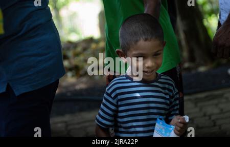 Enfant en attente de recevoir un colis de nourriture d'une communauté almsdonnant avec le visage heureux: Galle, Sri Lanka 30th juillet 2022 Banque D'Images