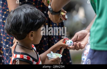 Enfant en attente de recevoir un colis de nourriture d'une communauté almsdonning ardemment: Galle, Sri Lanka 30th juillet 2022 Banque D'Images