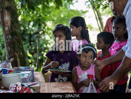 Enfant en attente de recevoir un colis alimentaire d'une communauté almsdonning: Galle, Sri Lanka 30th juillet 2022 Banque D'Images