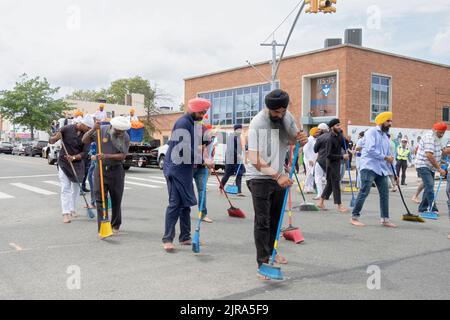 Devout Sikh hommes et femmes balaient Liberty Avenue où un défilé flottant porte leur livre Saint, Guru Granth Sahib, passera. Au Nagar Kirtan Parade. Banque D'Images