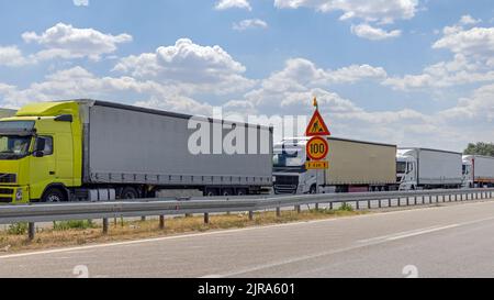 Longue file d'attente de camions cargo stuc à l'entrée de la frontière européenne Banque D'Images