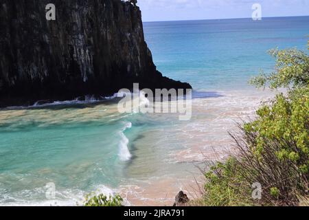 Vagues parfaites dans les eaux cristallines à côté de deux Brothers Cliff, plage de Cacimba, île de Fernando de Noronha, Brésil Banque D'Images