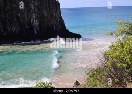 Vagues parfaites dans les eaux cristallines à côté de deux Brothers Cliff, plage de Cacimba, île de Fernando de Noronha, Brésil Banque D'Images