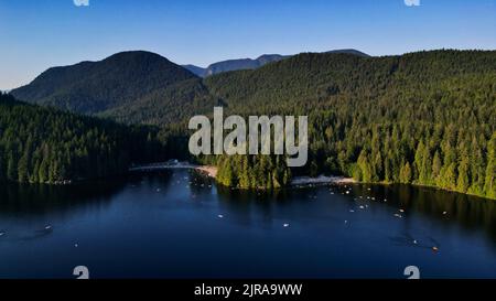 Une belle vue sur le lac Sasamat entouré d'arbres denses à Port Moody, Canada Banque D'Images