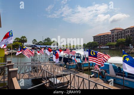 Malacca, Malaisie - 10 août 2022 : jetée du parc de la rivière Melaka et croisière, ornée de drapeaux malaisiens pour la journée nationale de la Malaisie. Touris Banque D'Images