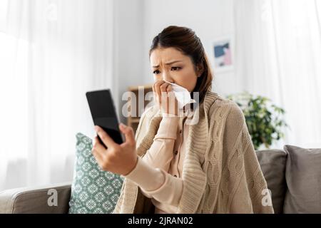 femme malade ayant un appel vidéo sur smartphone à la maison Banque D'Images