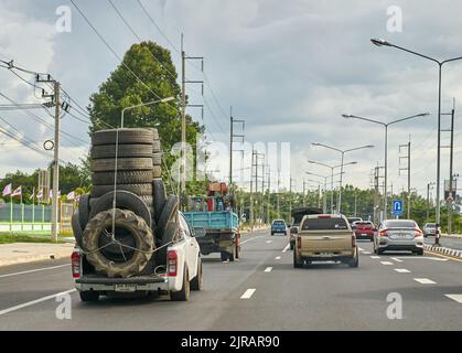 Un pick-up surchargé transportant des pneus en caoutchouc usagés pour le recyclage, pris en Thaïlande. Banque D'Images