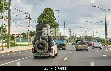 Un pick-up surchargé transportant des pneus en caoutchouc usagés pour le recyclage, pris en Thaïlande. Banque D'Images